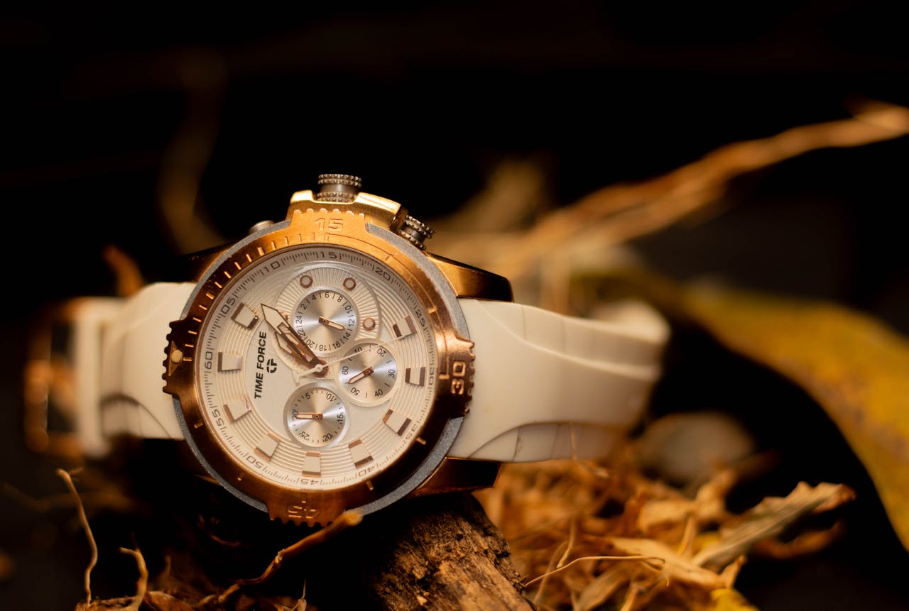 client-stories-img Detailed close-up of a stylish gold and white wristwatch on display with a rustic background.